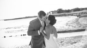 black and white image of couple kissing on the beach