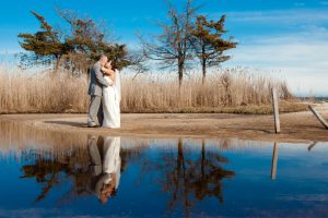 Bride and Groom kissing reflected in the water in outdoor setting