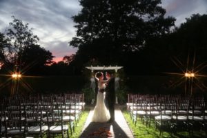 bride and groom in garden setting at dusk